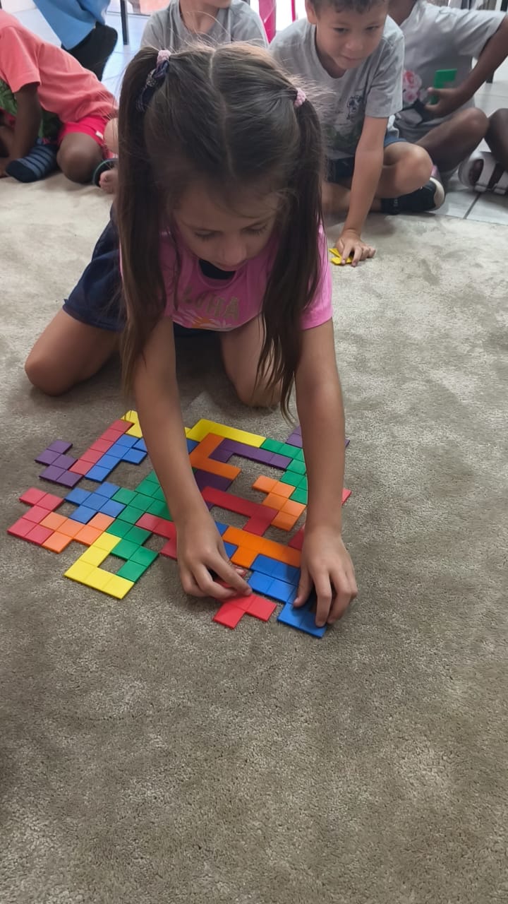 A young child at Luluki working on a wooden puzzle